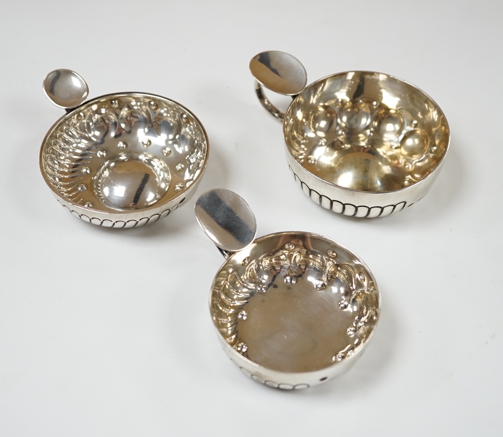 Three assorted late 19th/early 20th century French white metal taste vin, largest 11.1cm over handle.
